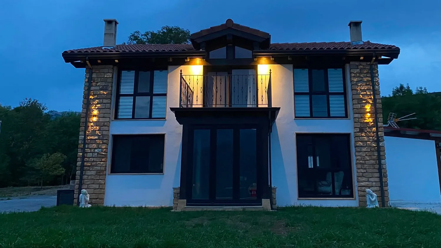 Fachada de Casa Calma iluminada al anochecer en el Valle de Soba, Cantabria