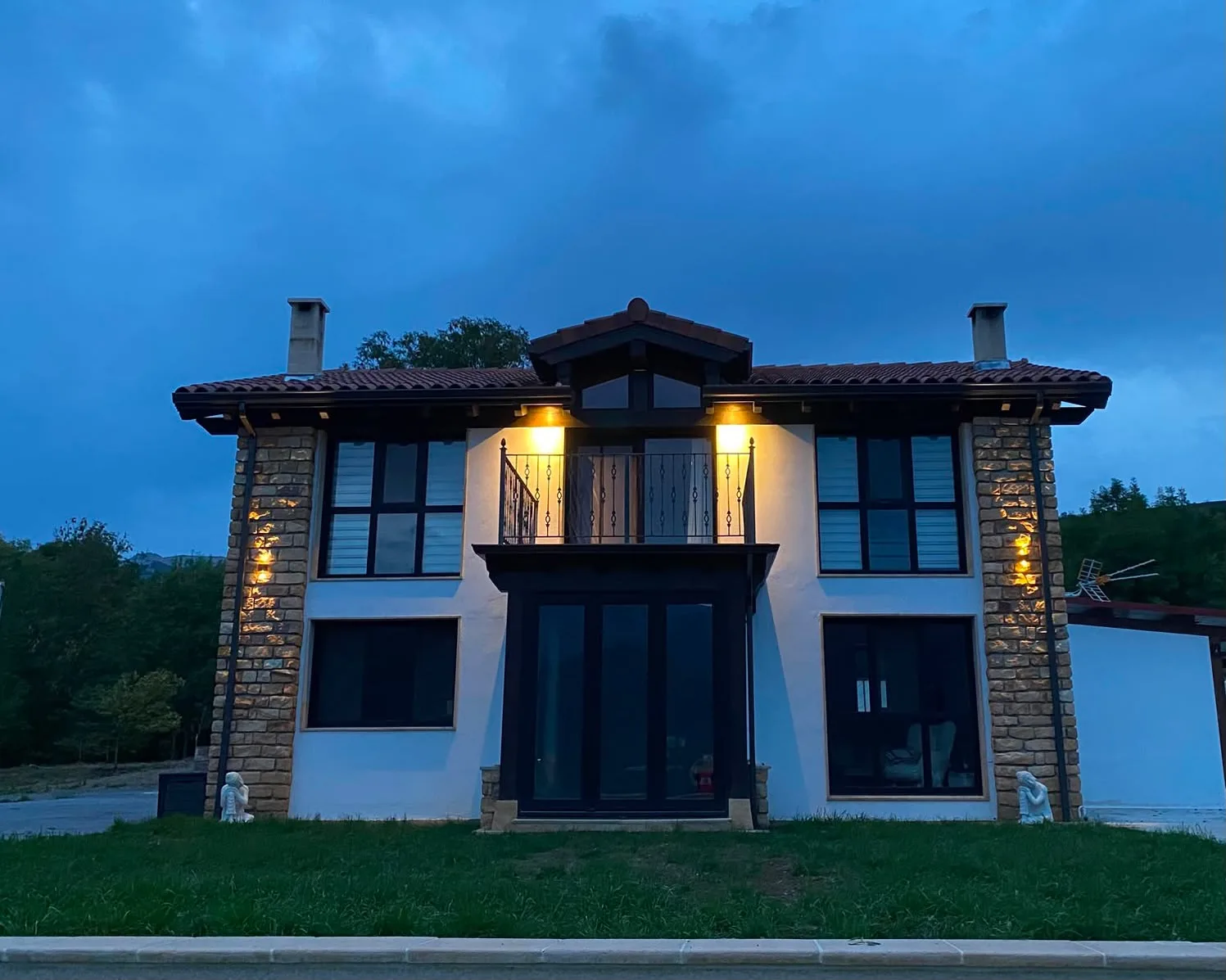 Fachada de Casa Calma iluminada al anochecer en el Valle de Soba, Cantabria